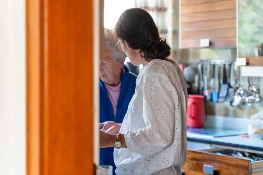 Pflegekraft der Diakoniestation Pforzheim im Beratungsgespräch zu Schmerzen im Alter mit einer Seniorin in der Küche