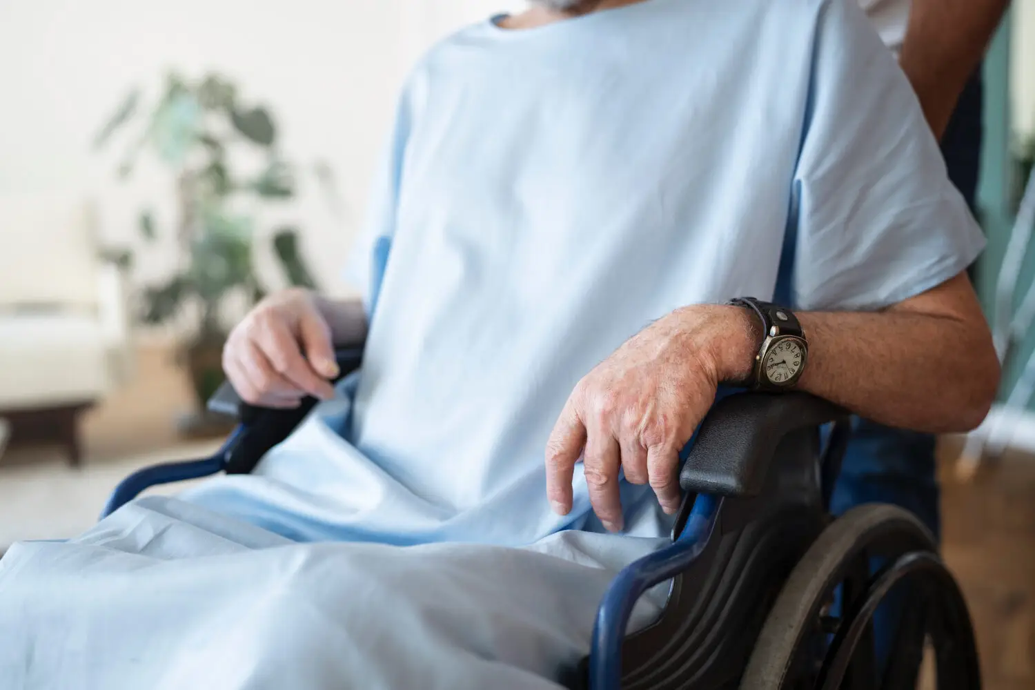 Senior sitzt zuhause im Rollstuhl, Pflegebedürftigkeit als Grund einen Pflegegrad zu beantragen